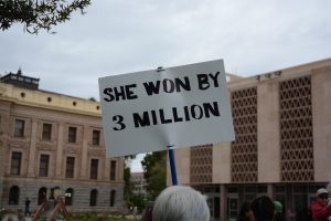 A woman held a sign that read “SHE WON BY 3 MILLION” in front of the Arizona State Capitol on Friday, Jan. 20, 2017. Several hundred protested the inauguration of President Donald Trump. (Photo by Ryan Santistevan/Cronkite News)