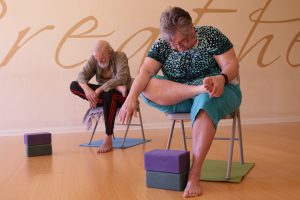 RJ Davis (right) and Geoffrey Davis take a chair yoga class at Inner Vision Yoga Studio in Chandler. (Photo by Ao Gao/Cronkite News)