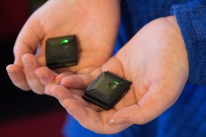 Buzzies display a green light when on and can be held, put into pockets or worn. (Photo by Megan Bridgeman/Cronkite News)