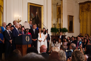 President Joe Biden addresses migrants and others in the East Room of the White House June 18, 2024. Sen. Mark Kelly, D-Ariz., stands to his left. (Photo by Benjamin Adelberg/Cronkite News)