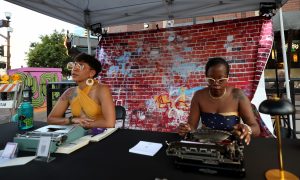 Chanté Summers and Sahina Jerome create personal haikus for attendees of the Juneteenth Block Party in Tempe, on June 15. Summers and Jerome work with Ars Poetica as traveling poets. (Photo by Stella Subasic/Cronkite News)