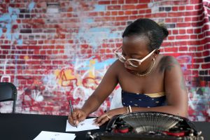 Sahina Jerome adds final details to a personalized haiku she typed for a Juneteenth Block Party attendee on June 15, in Tempe. Jerome has been a freelance poet for almost seven years. (Photo by Stella Subasic/Cronkite News)